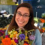 Woman smiling facing the camera while holding flowers